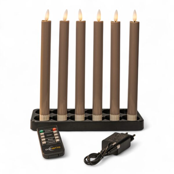 Home 20 Sechs batteriebetriebene braune Kerzen mit flammenförmigen Spitzen sind in einem schwarzen rechteckigen Ständer angeordnet. Davor befinden sich eine Fernbedienung mit beschrifteten Tasten und ein schwarzer Stromadapter mit Kabel.