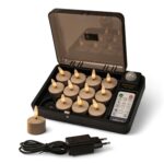 Ein Set mit zwölf flammenlosen LED-Teelichtern in einem Ladekoffer mit Fernbedienung und Netzadapter, ein Teelicht wird außerhalb des Koffers platziert.